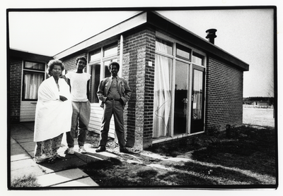 107727 Afbeelding van een Ghanese familie bij één van de bungalows van het als asielzoekerscentrum ingerichte ...
